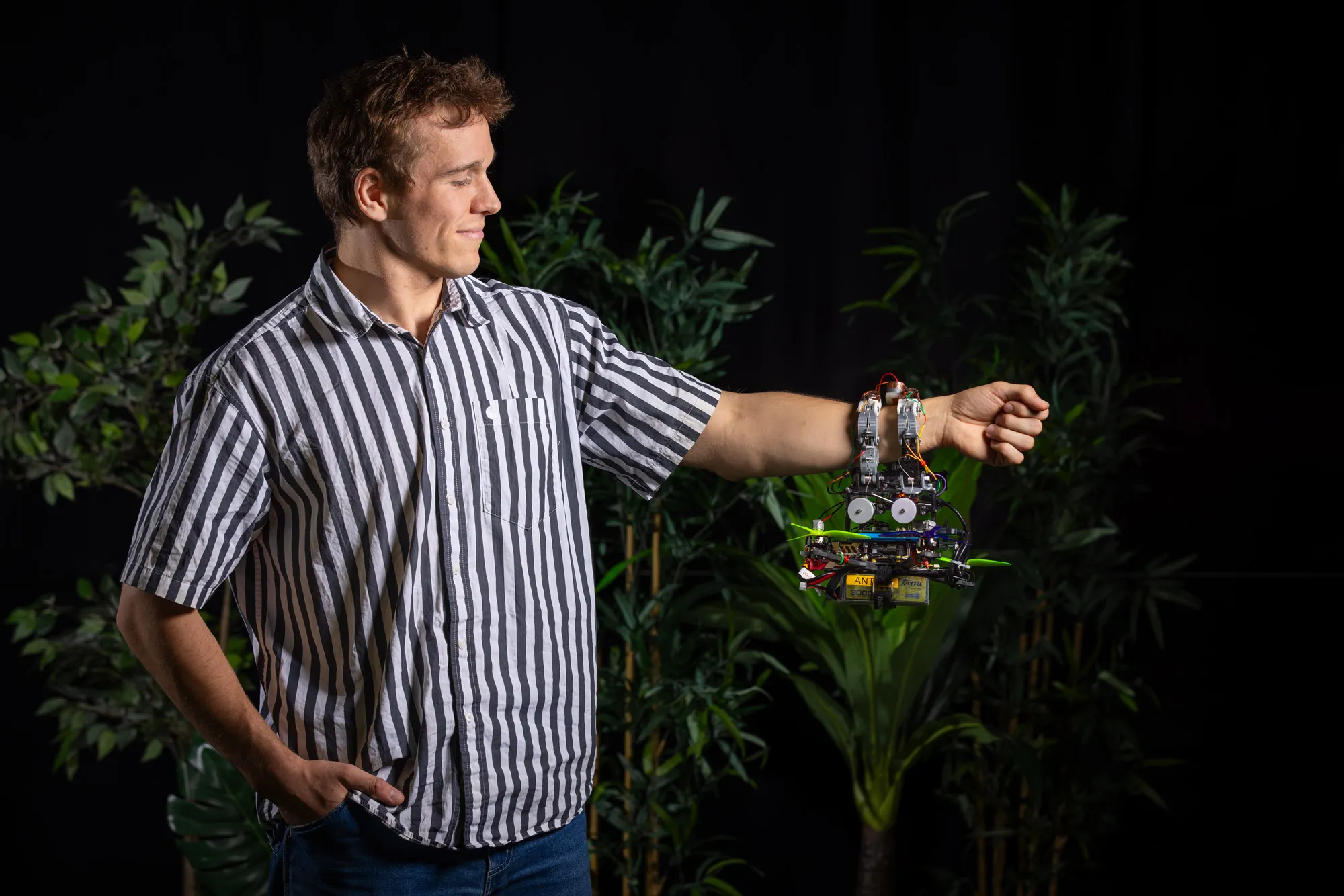 A researcher holding a drone with a soft tactile gripper that feels for a branch before landing